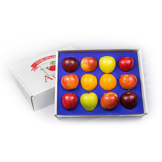 Box of assorted colored apples and oranges in a box on a white background.
