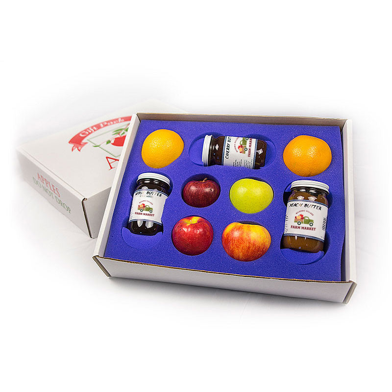 Set of jars and fruits in a box on a white background.