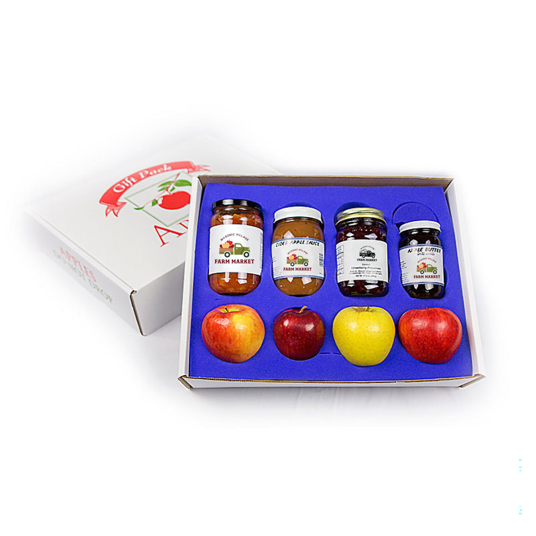 Set of jars and apples in a gift box on a white background.