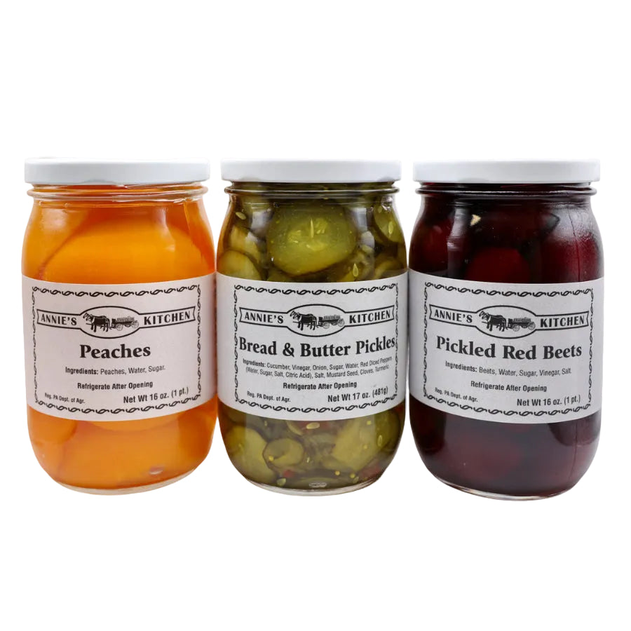 Three jars of preserved fruits and vegetables with labels on a white background