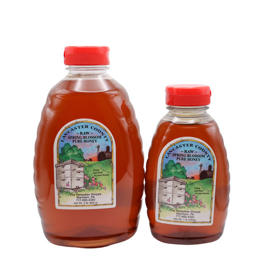Two bottles of honey with labels on a white background